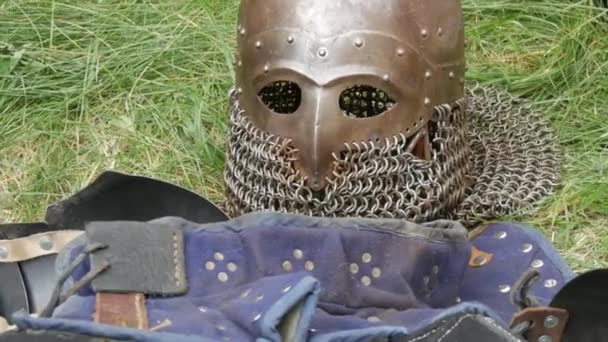Knights armor, helmet, armor, iron gauntlets lie on the grass after the battle — Stock Video