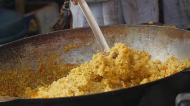 Büyük bir tabak pilav ya da pilav, aşçının yemek aldığı. Sokak yemeği festivali, büyük miktarda yiyecek.