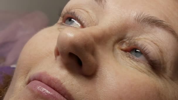 Cara de mulher adulta no procedimento moderno de laminação de pestanas em um salão de beleza profissional após o procedimento de ondulação de pestanas. — Vídeo de Stock