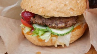 Büyük bir hamburgerle tezgah ya da büyük bir pirzola, salatalık ve salatalık sosu ile sokak yemeği festivalinin tezgahında. Şişko, sağlıksız fast food 'lar manzarayı kapatır