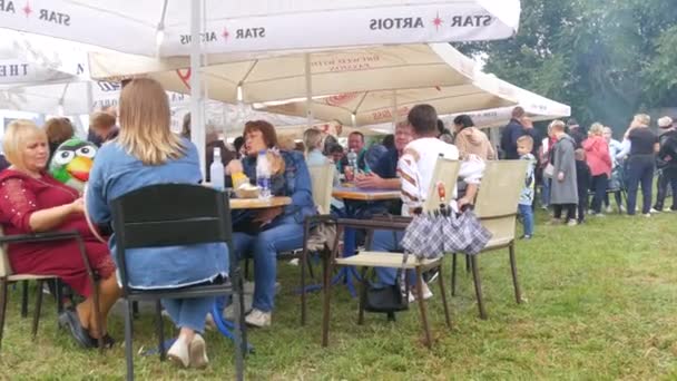 4 september 2021 - Petrykivka, Oekraïne: De eetzaal van het straatvoedselfestival waar veel mensen aan tafel zitten en eten, buiten feesten — Stockvideo