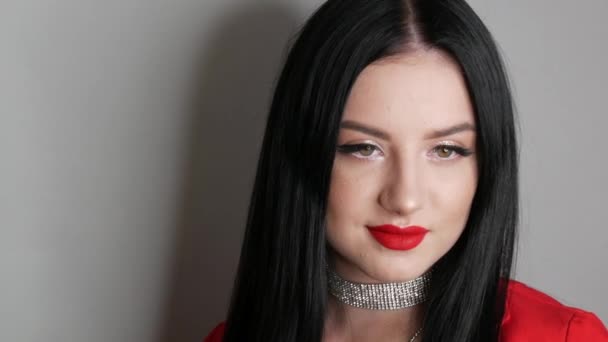 Hermosa modelo de niña con labios grandes pintados con lápiz labial rojo. Mujer joven posando en elegantes collares rojos Blazer hechos de diamantes de imitación y maquillaje de noche brillante, mirando a la cámara — Vídeos de Stock