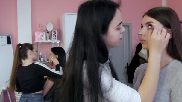 Kamenskoe, Oekraïne - 26 maart 2021: Professionele make-up kunstenaars en stylisten werken aan het imago van de modellen waardoor ze make-up — Stockvideo
