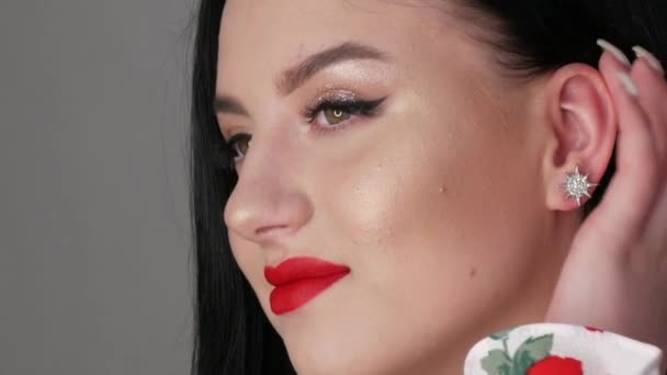 Close-up uitzicht op mooi meisje model met grote lippen beschilderd met rode lippenstift. jonge vrouw poseren met heldere avond make-up — Stockvideo
