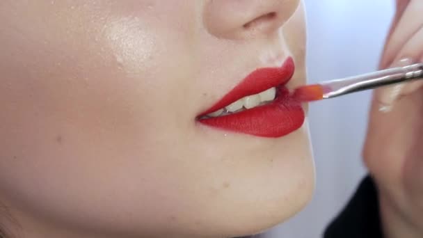 밝은 입술 화장 과커다란 아름다운 입술은 아름다운 미용실 에 특별 한 솔이 달린 빨간 립스틱 으로칠 해져 있다. 전문 화장이요. 검은 화살로 화장하는 일 — 비디오