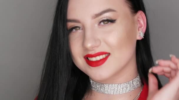 Schöne Mädchen Modell mit großen Lippen mit rotem Lippenstift bemalt. Junge Frau posiert in stylischen roten Blazer-Halsketten aus Strass und leuchtendem Abendschmink und blickt in die Kamera — Stockvideo