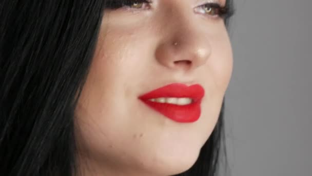 Close-up uitzicht op mooi meisje model met grote lippen beschilderd met rode lippenstift. jonge vrouw poseren met heldere avond make-up — Stockvideo