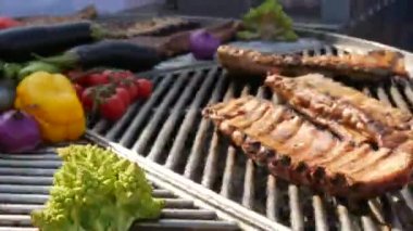 Kızarmış domuz kaburgalarının yanında sebzeler, domatesler, paprikalar, soğanlar, patlıcan, kabak ve bitkiler kızartılır. Sokak Yemekleri Festivali. Kızarmış, kömür ızgarasında sağlıksız yemek.