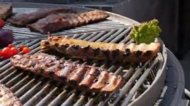 Kızarmış domuz kaburgalarının yanında sebzeler, domatesler, paprikalar, soğanlar, patlıcan, kabak ve bitkiler kızartılır. Sokak Yemekleri Festivali. Kızarmış, kömür ızgarasında sağlıksız yemek.