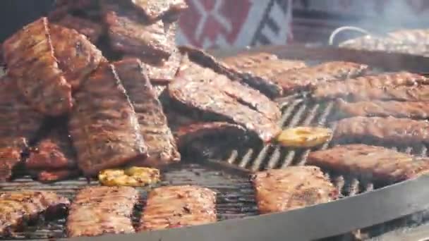 Kızarmış domuz pirzolası büyük bir ızgarada kızartılır. Sokak Yemekleri Festivali. Kızarmış, sağlıksız yemekler. — Stok video