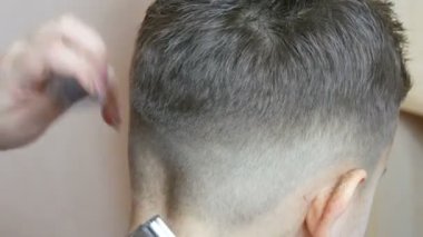 20 Ocak 2021 - Kamenskoe, Ukrayna Kuaför bir çocuğun saçını kesiyor ve bir müşteri için yeni bir saç stili yapıyor.