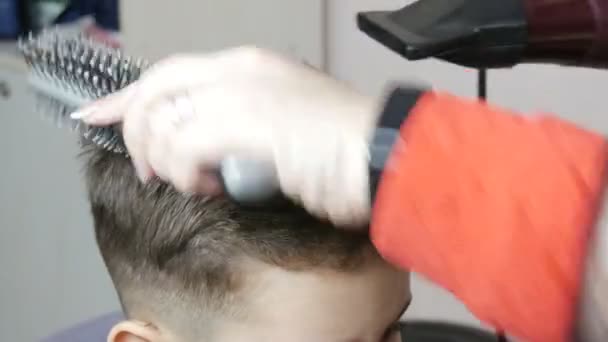 20 januari 2021 - Kamenskoe, Ukraina: Frisören i salongen klipper ett barn hår och gör en ny frisyr för en kund — Stockvideo