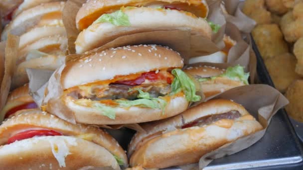 Spousta hamburgerů nebo hamburgerů na pultu slavnosti pouličních jídel. Nezdravé jídlo — Stock video