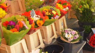 Yerel bir Fransız pazarında güzel buketler dolusu karışık taze çiçek. Küçük işaretlerle Fransızca yazılmış fiyatlar. Canlı renkler ve şenlikli çiçek düzenlemeleri