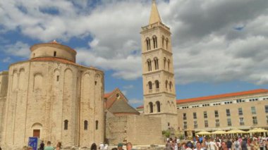 9 Juli 2025 Zadar, Hırvatistan: St. Donatus Kilisesi ve Zadar Katedrali 'nin Roma çan kulesi Hırvatistan' ın tarihi merkezindeki dramatik bulutlu gökyüzüne karşı yükseliyor. Site turistlerle dolup taşıyor. Bu ikonik simgenin tadını çıkarıyorlar.