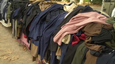 Toprakta sanatsal kıyafetler ve pazarda duran pastel renkler. Sıcak dokuları, sakin yaşam tarzını ve çevreye duyarlı modayı yansıtır..