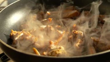 Et tavada kızarıyor, buhar yükseliyor ve güneş ışığı yansıyor. Sıcak ev mutfağı pişirme anı