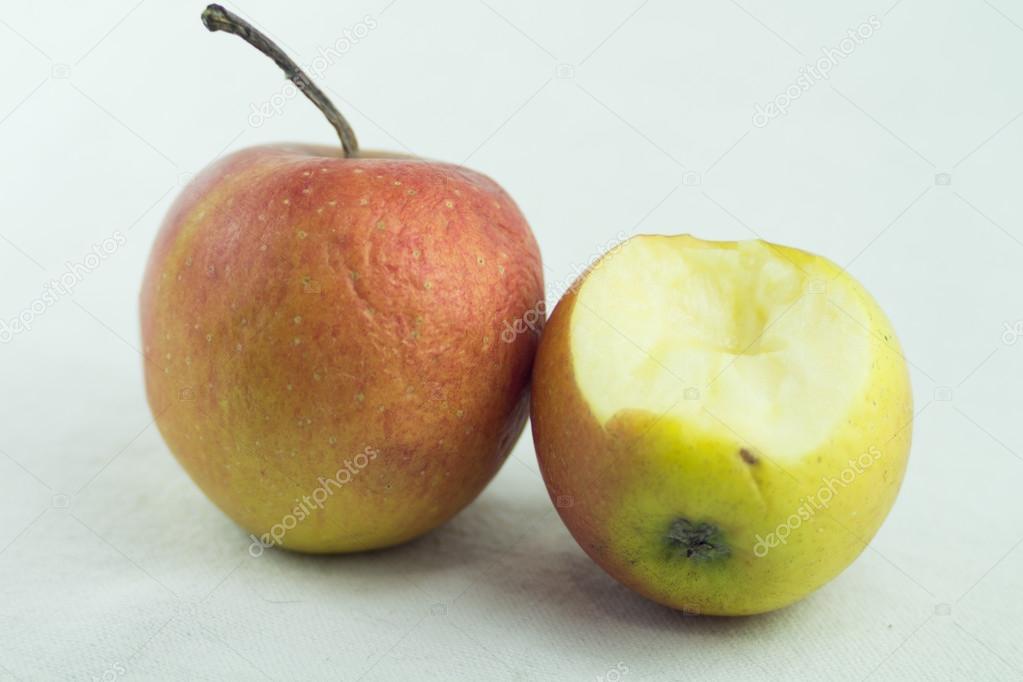 Two spoiled and bitten red apples