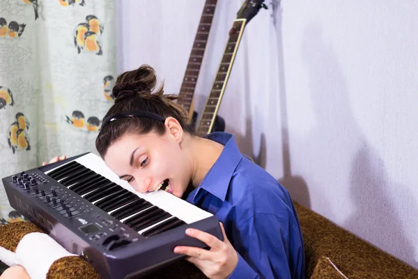 Genç güzel kız klavye oynamak için öğrenme