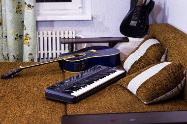 Kahverengi kanepe evde yatan synthesizer