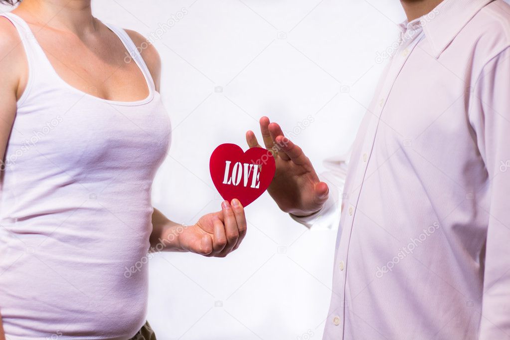 Young beautiful couple holding red heart