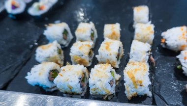 Seçici odak noktasında Masada Suşi Tutan Kişinin Kesilmiş Resmi