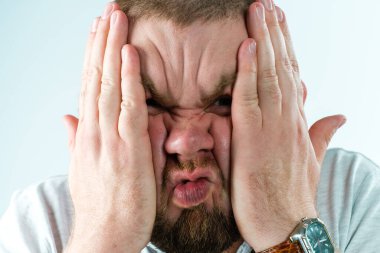 Adam elleri her iki tarafta da yüzünü buruşturdu.