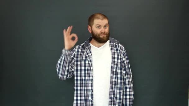 Un carismático barbudo de apariencia eslava muestra el signo OK con su mano. — Vídeos de Stock