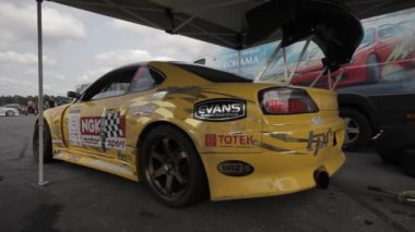 Sarı yarış arabası park yerinde - Dolly ile filme alındı.