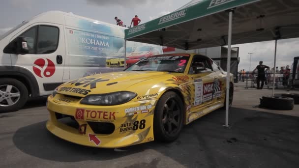 Κίτρινο αγωνιστικό αυτοκίνητο στο πάρκινγκ - γυρίστηκε με dolly — Αρχείο Βίντεο