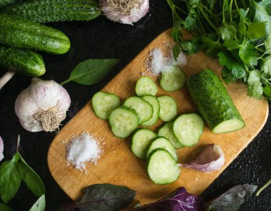 Dilimlenmiş salatalıklar küçük bir tahtanın üzerinde duruyor.