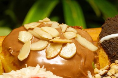 Tahta masadaki badem minnacık çöreğe yakın ve sığ odak noktasında.