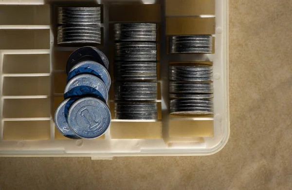 One Yen on the coin box, in shallow focus. Saving money concept, cash management