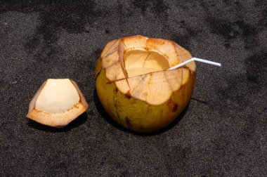 Endonezya 'nın güneyindeki karanlık kumlu sahilde taze hindistan cevizi meyvesi seçilmiş..