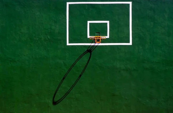 篮球圈 阴影笼罩在绿色的水泥墙上 — 图库照片