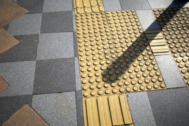 Körler için sarı dokunmatik kaldırımlar ya da kaldırımda görme engelliler için..