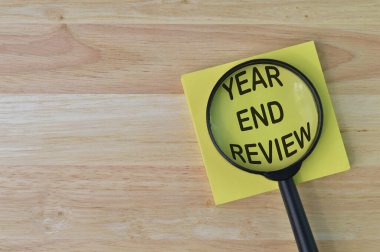 Metin YIL SONRA REViEW ile yazılmış büyüteç ve not üst görünümü.