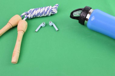 İp, kulaklık ve su şişesi, yeşil arka planda fotokopi alanı ile atlanıyor