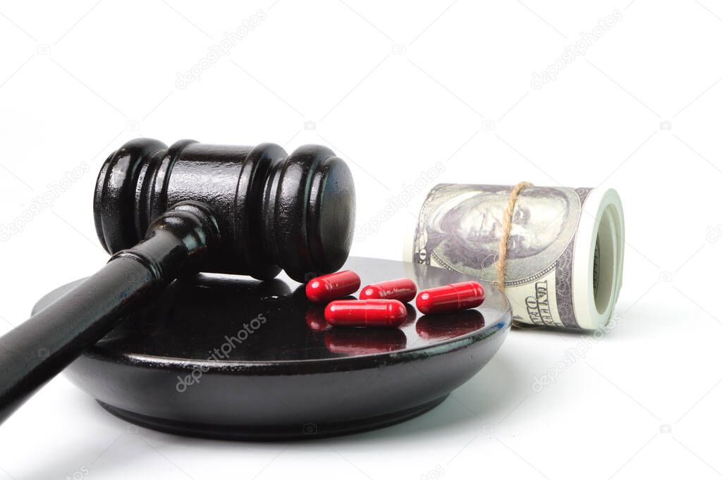 Judge hammer, pill capsules and money banknotes over white background