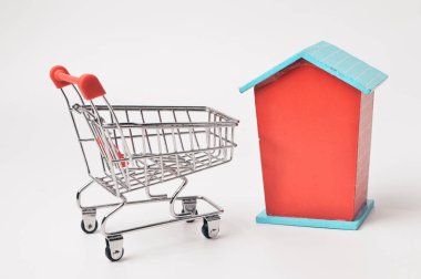 Oyuncak ev ve alışveriş arabası beyaz arka planda.