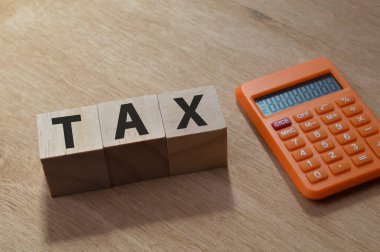 Vergi ile yazılmış hesap makinesi ve tahta küplerin üst açı görünümü.