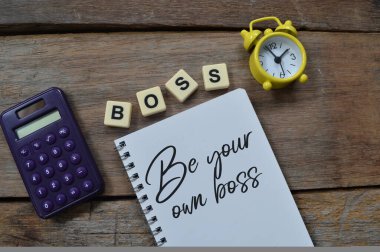 Saatin üst görünümü, hesap makinesi kare harfleri, metin BOSS ve kendi patronun olarak yazılmış defter..