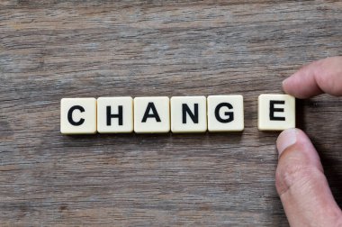 Tahta zemin üzerinde metin değişikliğiyle Scrabble harflerinin üst görünümü.