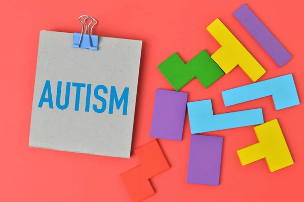 Colorful wooden blocks and memo note written with text AUTISM.