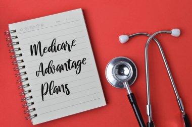 Stetoskop ve not defteri, metin MEDICARE ADVANTAGE PLANS ile yazıldı.