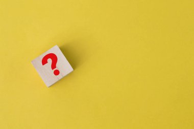 Tahta blokta sarı arkaplan üzerine soru işareti çizildi