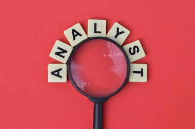 Metin ANALYST ile büyüteç ve scrabble harfleri.