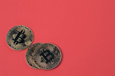 Kırmızı arkaplan üzerinde kopyalama alanı olan altın bitcoinler.