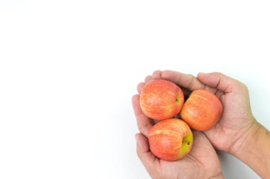 Beyaz arka planda kırmızı elmaları tutan