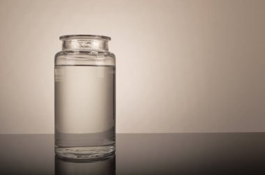 Masada su olan cam kavanoz.